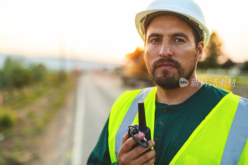 西班牙工人设置障碍和指挥交通街道道路和高速公路建设摄影系列的专心肖像