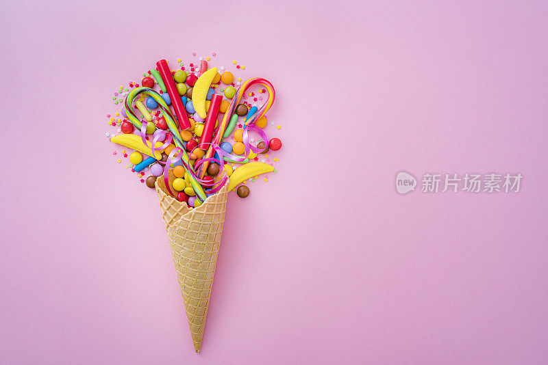 粉色背景上有糖果的冰淇淋蛋筒