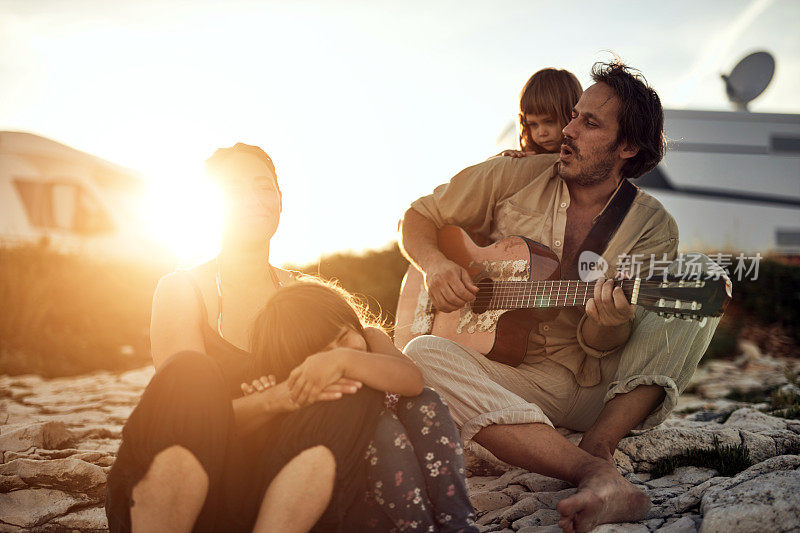 一家人在度假，唱歌，弹吉他，享受夏日的氛围。