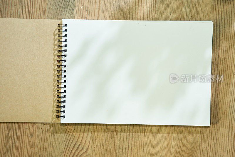 木桌面上的空白素描本