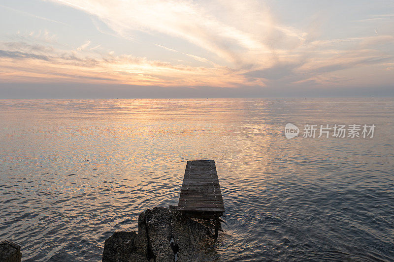 日出时海上的木制码头