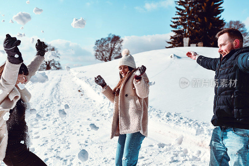 快乐的朋友在山上享受寒假的有趣的雪派对