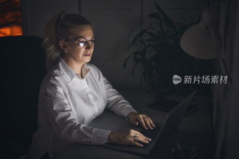 女人在办公室用笔记本电脑工作到深夜