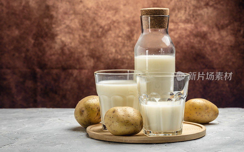 玻璃素食土豆奶和生土豆。替代植物奶。超级食品的概念。健康,干净的吃。素食或无麸质饮食。横幅，菜单，食谱文本的地方