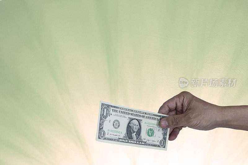 人类手中的美元模糊的绿色射线背景