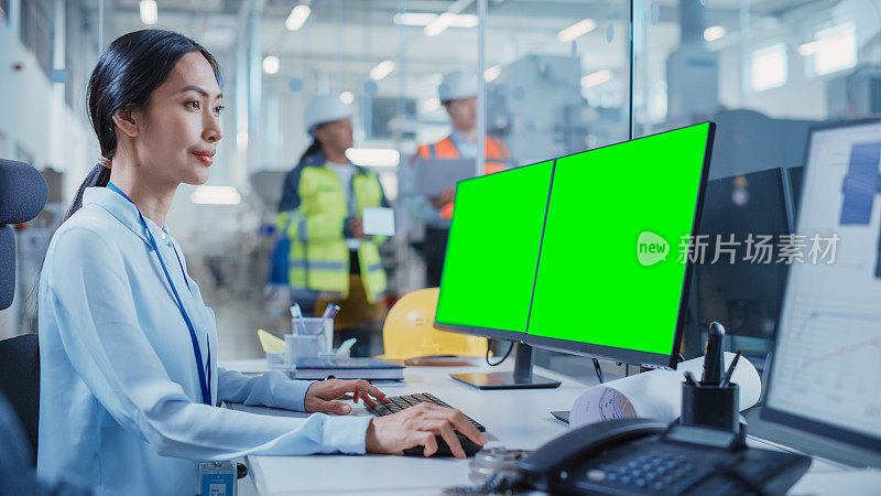 工厂办公设施:工业工程师在计算机CAD软件上起草重工业机器零件的蓝图。一台计算机显示器显示是一个绿屏模拟模板。