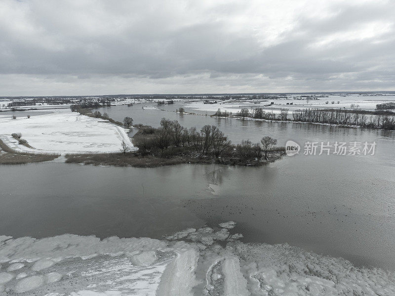 洪水泛滥的IJssel河在积雪的冬季景观附近Kampen