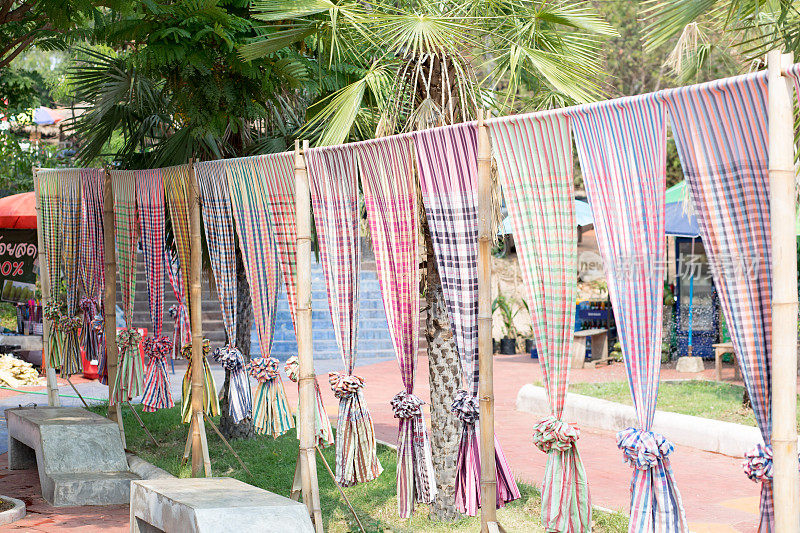一行与丰富多彩的泰国围巾和桌布装饰在湄公河精神的地方