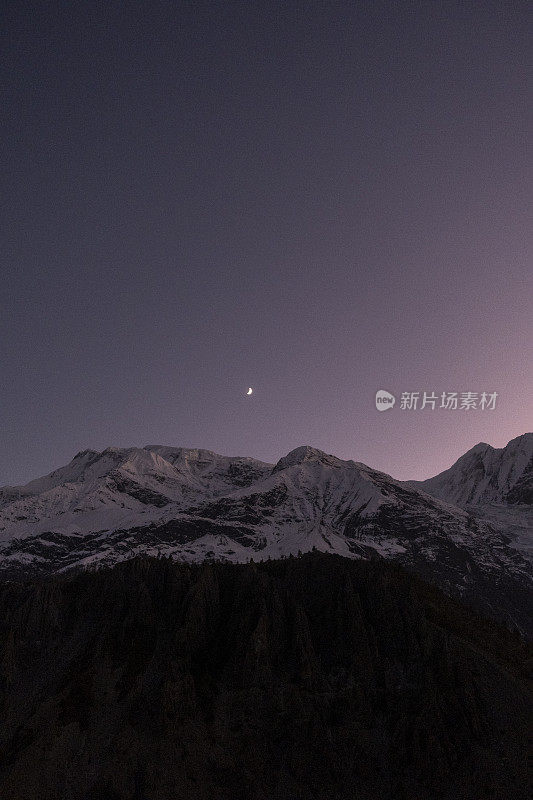 彩色浪漫的夜空在雪山之上。白雪皑皑的山峰映衬着星空的背景。