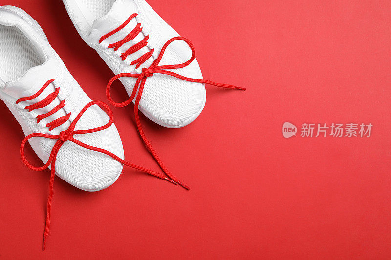 时尚运动鞋鞋带在红色背景，平lay。文本空间
