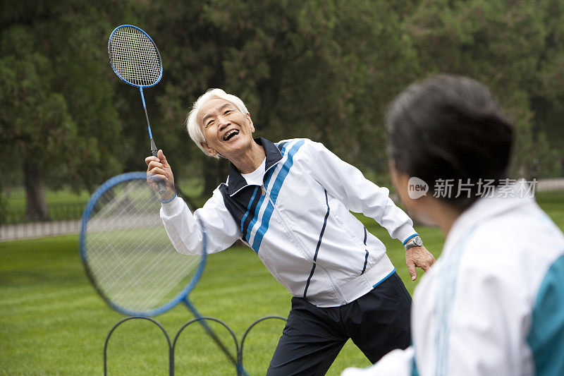 老年夫妇在公园打羽毛球