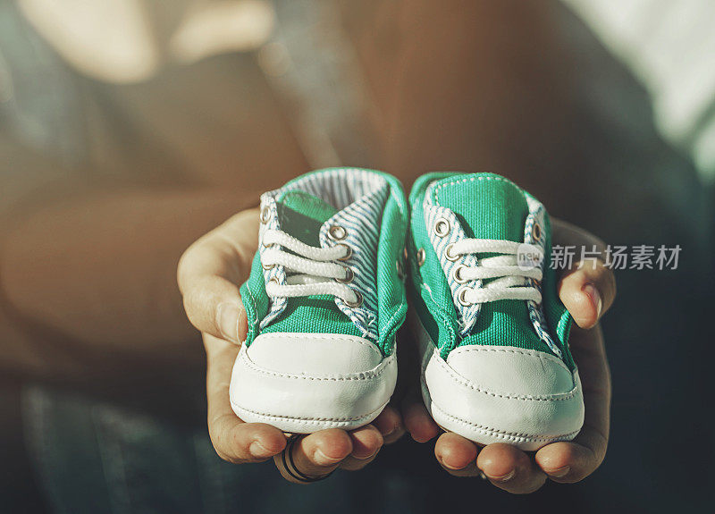 未来的父母抱着一双小鞋子