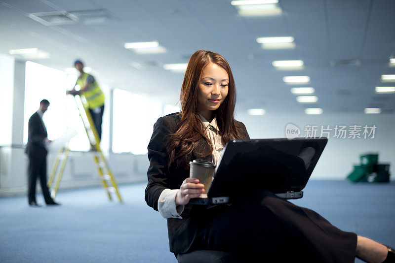 年轻女商人在空荡荡的办公室里