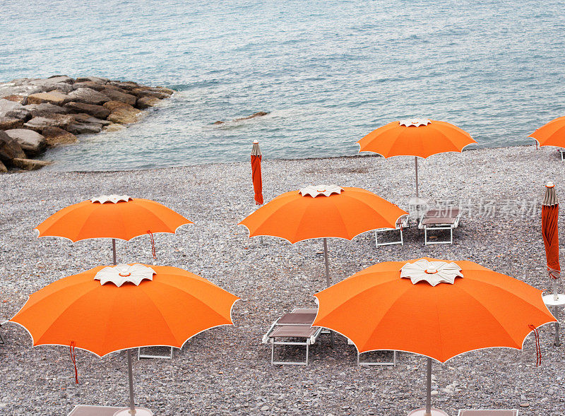 橙色雨伞和日光浴床