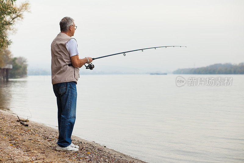 一位老人在阴天钓鱼