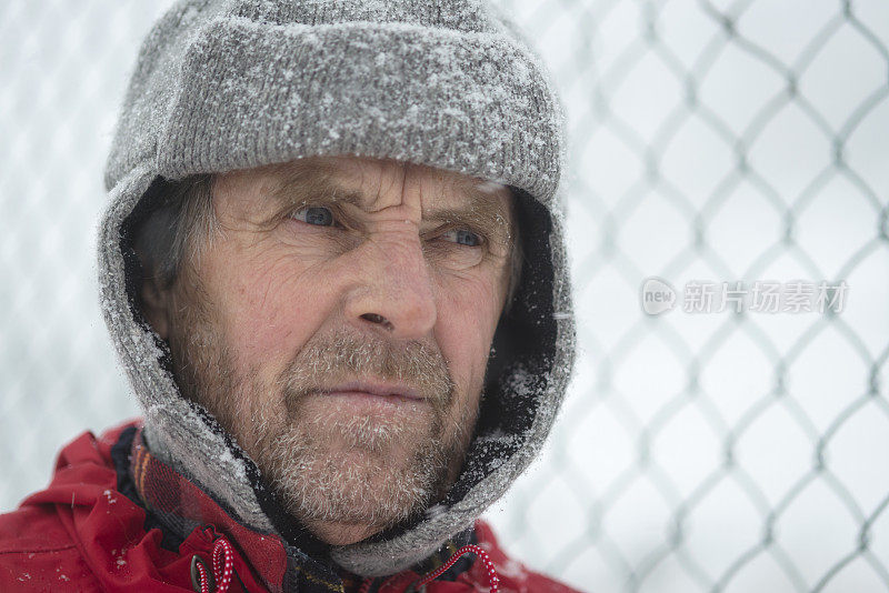 高级男子在营地围栏，下雪，朱利安阿尔卑斯，欧洲