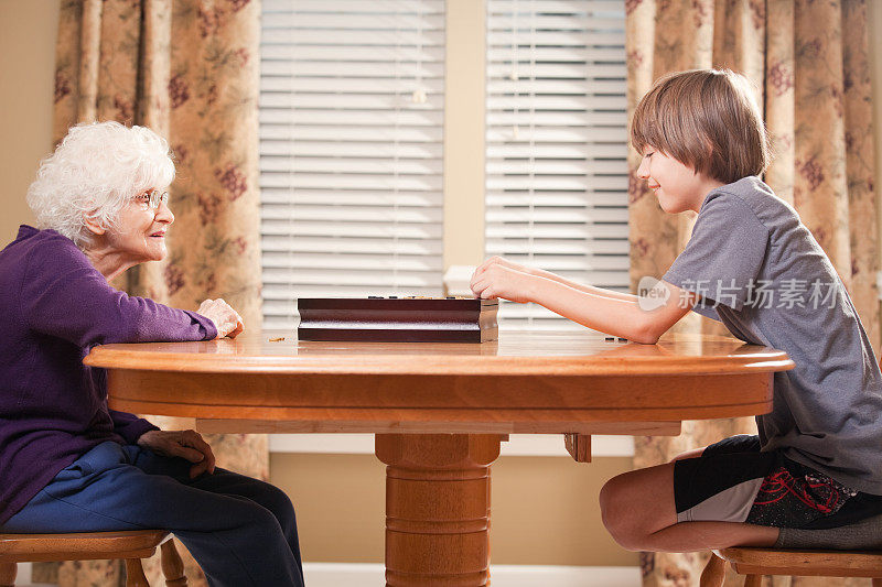 男孩和他的祖母在玩跳棋