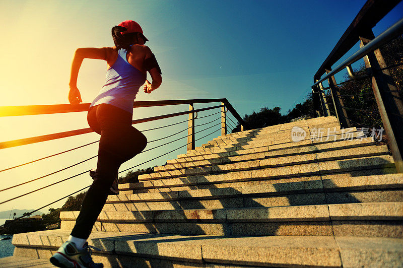 健康的生活方式亚洲妇女在楼梯海边跑步