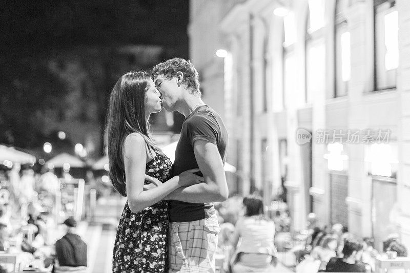 年轻情侣在浪漫的户外欧洲咖啡馆接吻