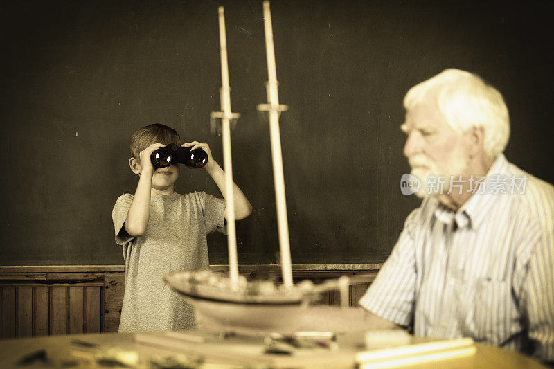 男孩与双筒望远镜和高级男子模型造船师