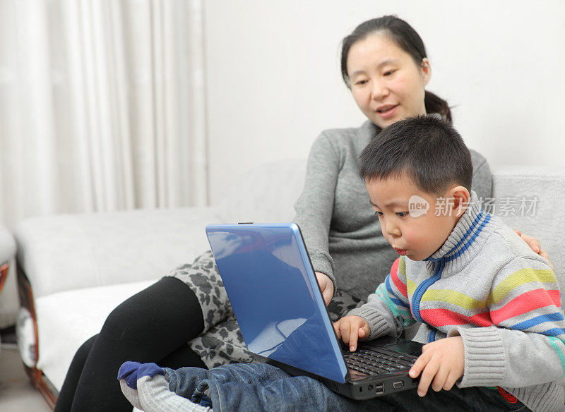 妈妈在家里教儿子使用电脑