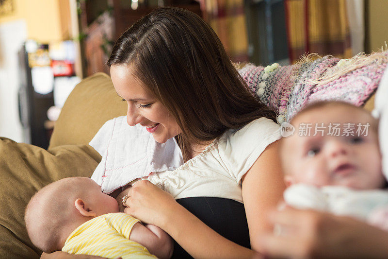 年轻母亲在护理支持小组会议上母乳喂养婴儿