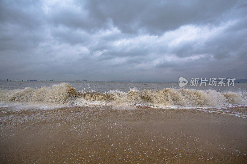 阴天下海浪在海滩上冲浪