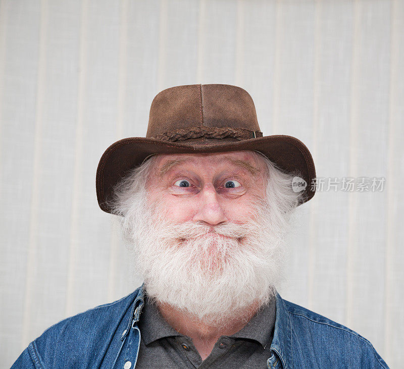 快乐有趣的长胡子的老年人，大眼睛和皮帽