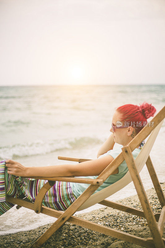 穿着夏装的女人望着天空和大海