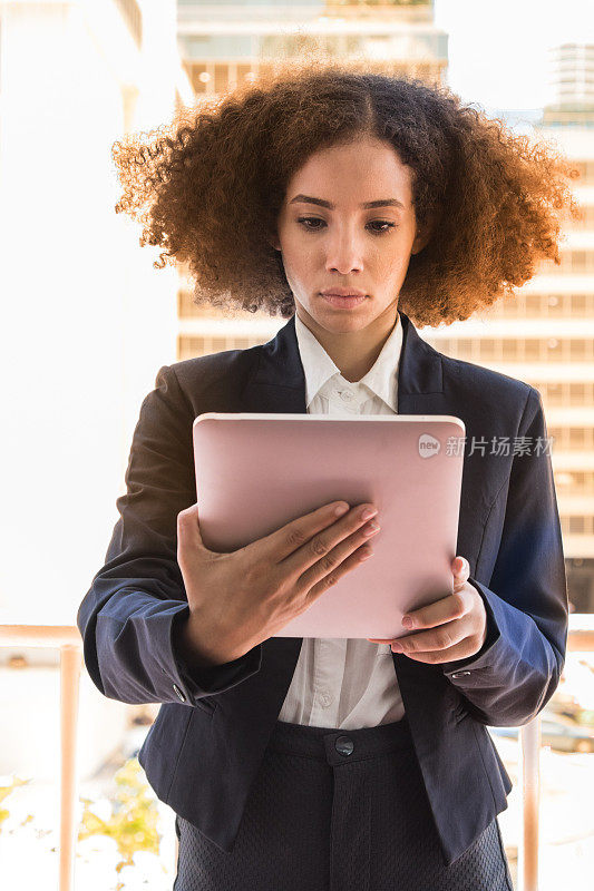 年轻的女商人看着她的数字平板电脑