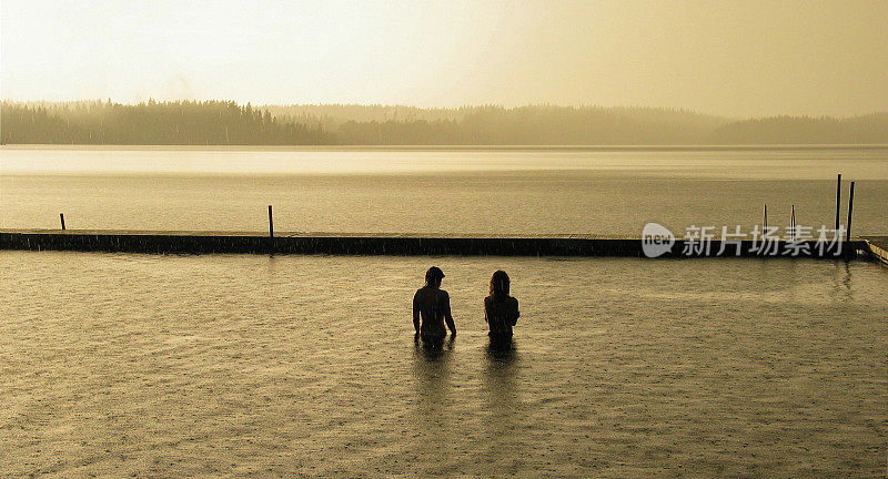 一名少年和一名少女站在夕阳下的雨中