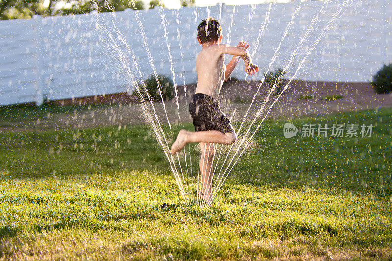 孩子在洒水器上奔跑