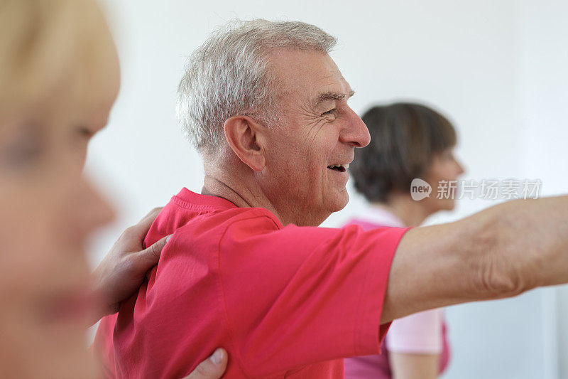 瑜伽教练向老年人展示武士姿势