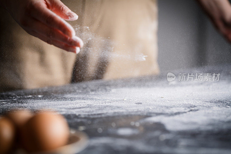 面包师用手撒面粉