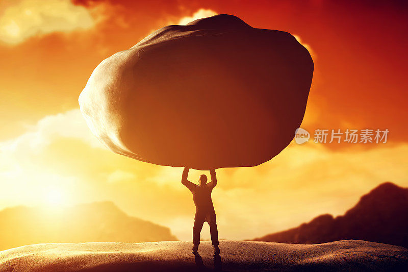一个人举起一块大石头。力量，压载，困难，力量的概念