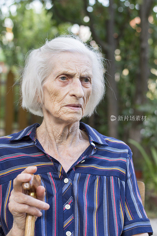 一个拄着拐杖的九十岁老妇人的肖像