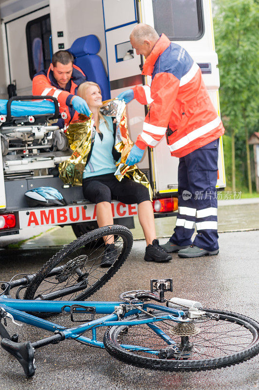紧急护理人员帮助女性自行车事故