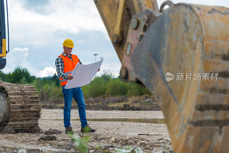 挖掘机司机正在检查图纸