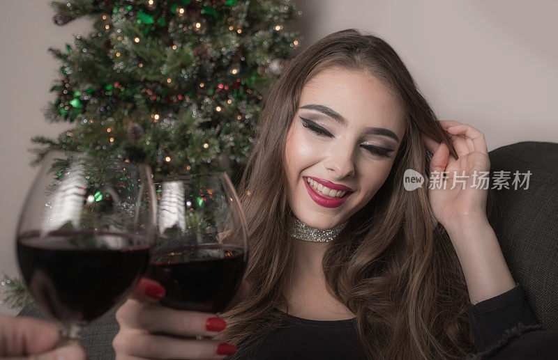 在圣诞节和迷人的年轻女子碰杯
