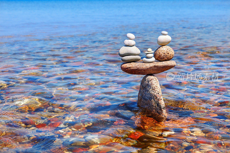 水中矗立的石头的象征尺度。平衡的概念。