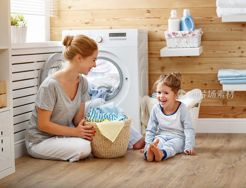 幸福的家庭，母亲，家庭主妇和孩子在洗衣机洗衣机