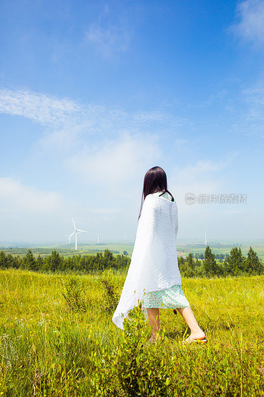 年轻女子站在大草原上