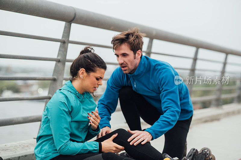 一个健康的男人在帮助一个腿部受伤的女人