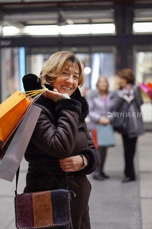 幸福老年女人晚上在城里购物