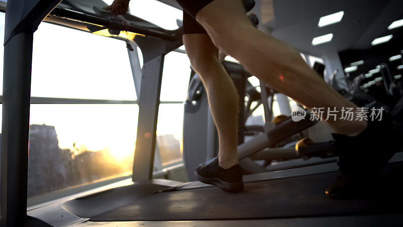 运动员在健身房跑步机上跑步，锻炼前热身，保健