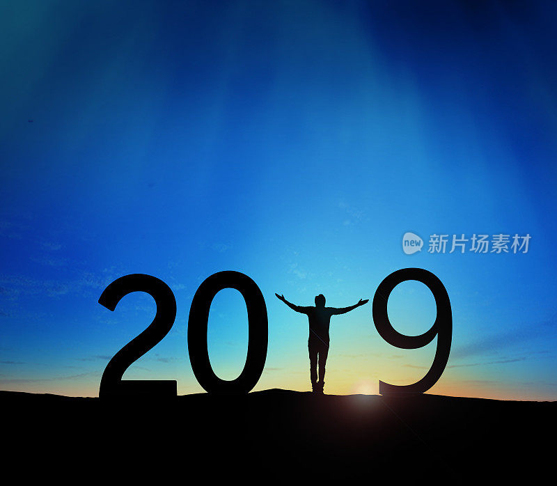 2019年，一个成功男人站在山上举手的剪影