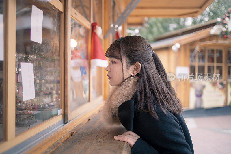 年轻女子在圣诞市场购物