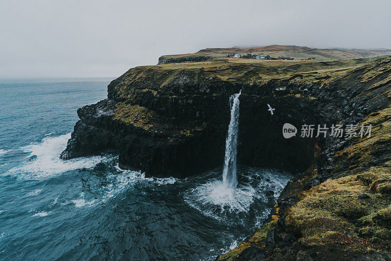 在法罗群岛的风景Múlafossur瀑布坠入大海