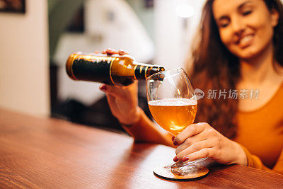 年轻漂亮的女人在酒吧喝啤酒