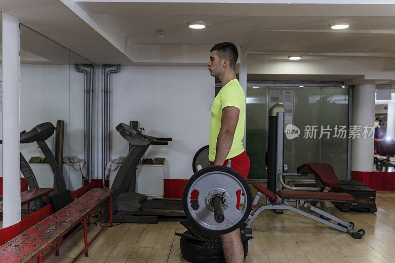 一名年轻的健美运动员正在健身房练习举重